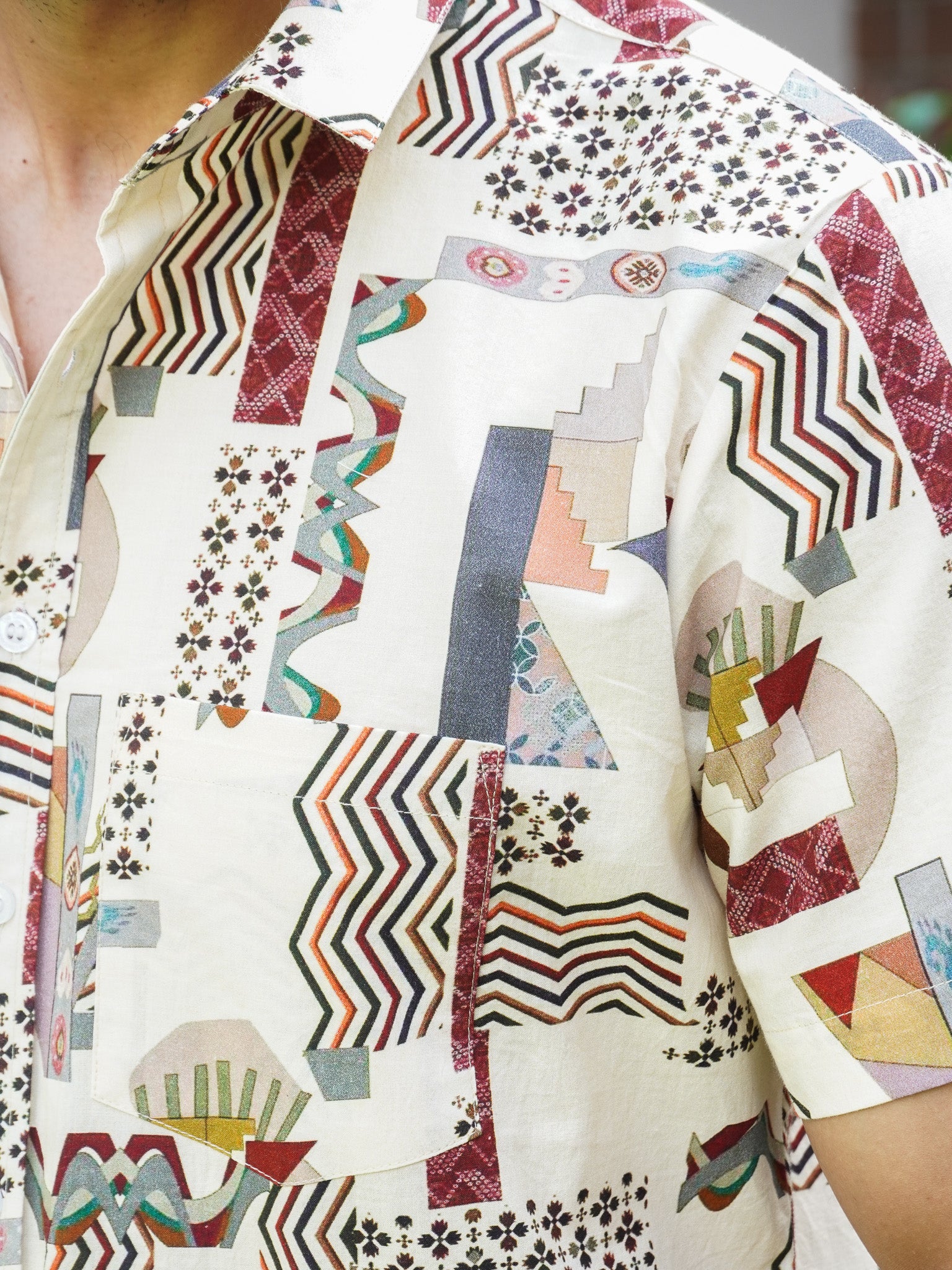 Close-up of multicolour geometric and zigzag print on beige cotton shirt
