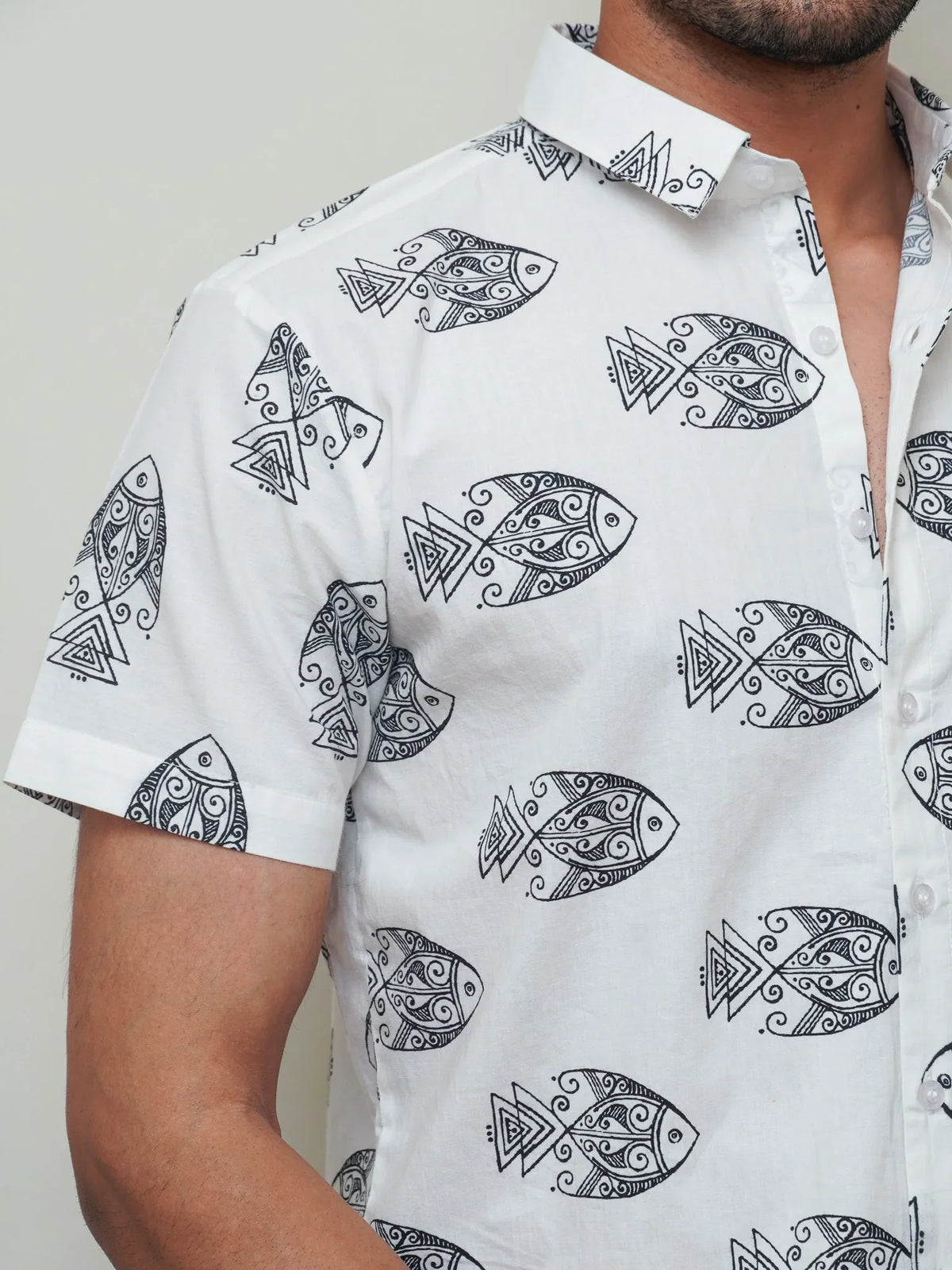 Close-up of bold black illustrated fish motifs on white fabric