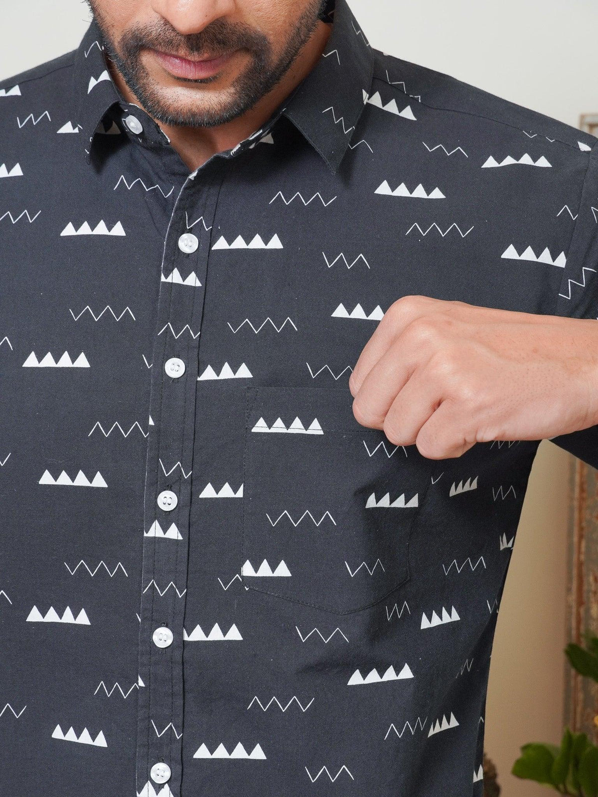 Close-up of white zigzag triangle and line motifs on black fabric