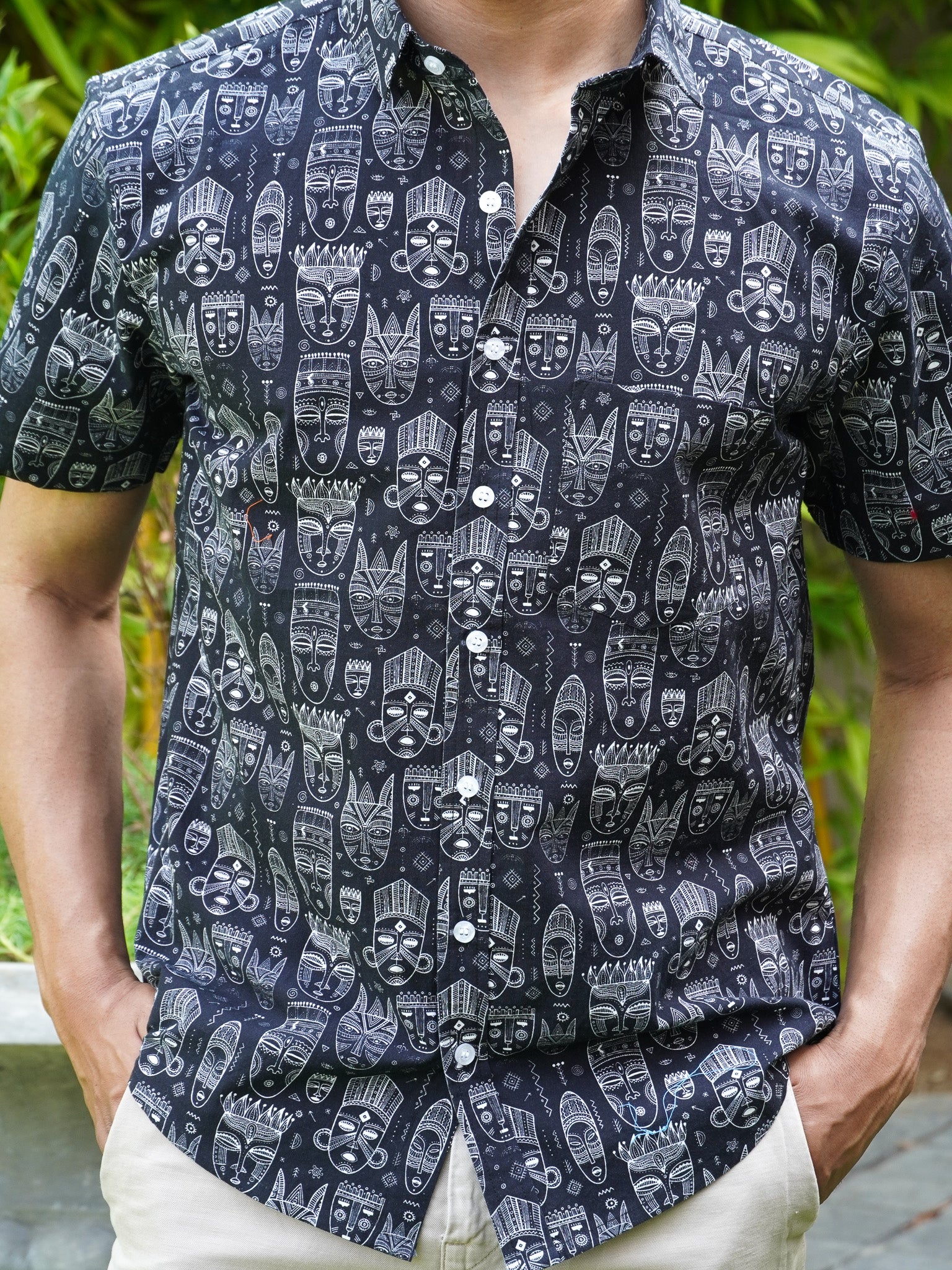 Close-up of white and grey tribal art motifs on black cotton shirt