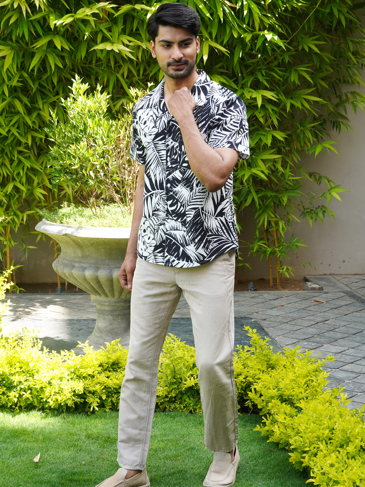 Model wearing men’s black and white tropical leaf print shirt