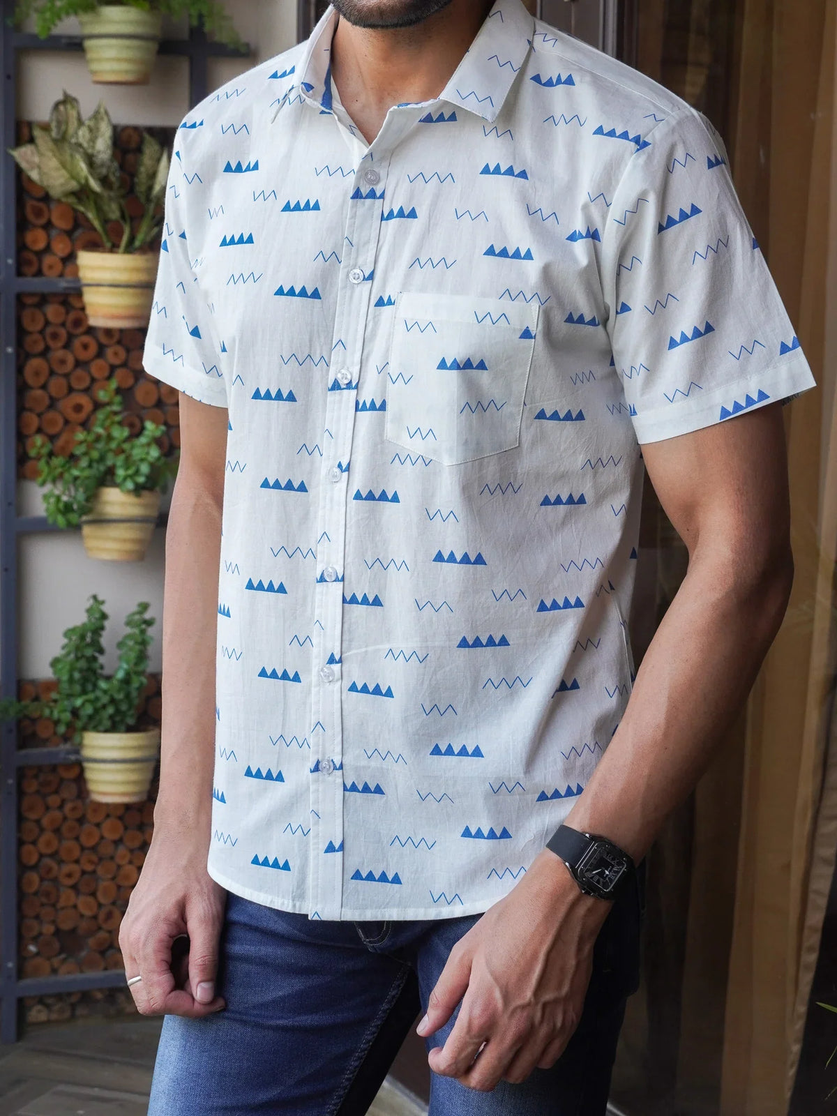 Close-up of blue triangles zigzags and wave motifs on white cotton