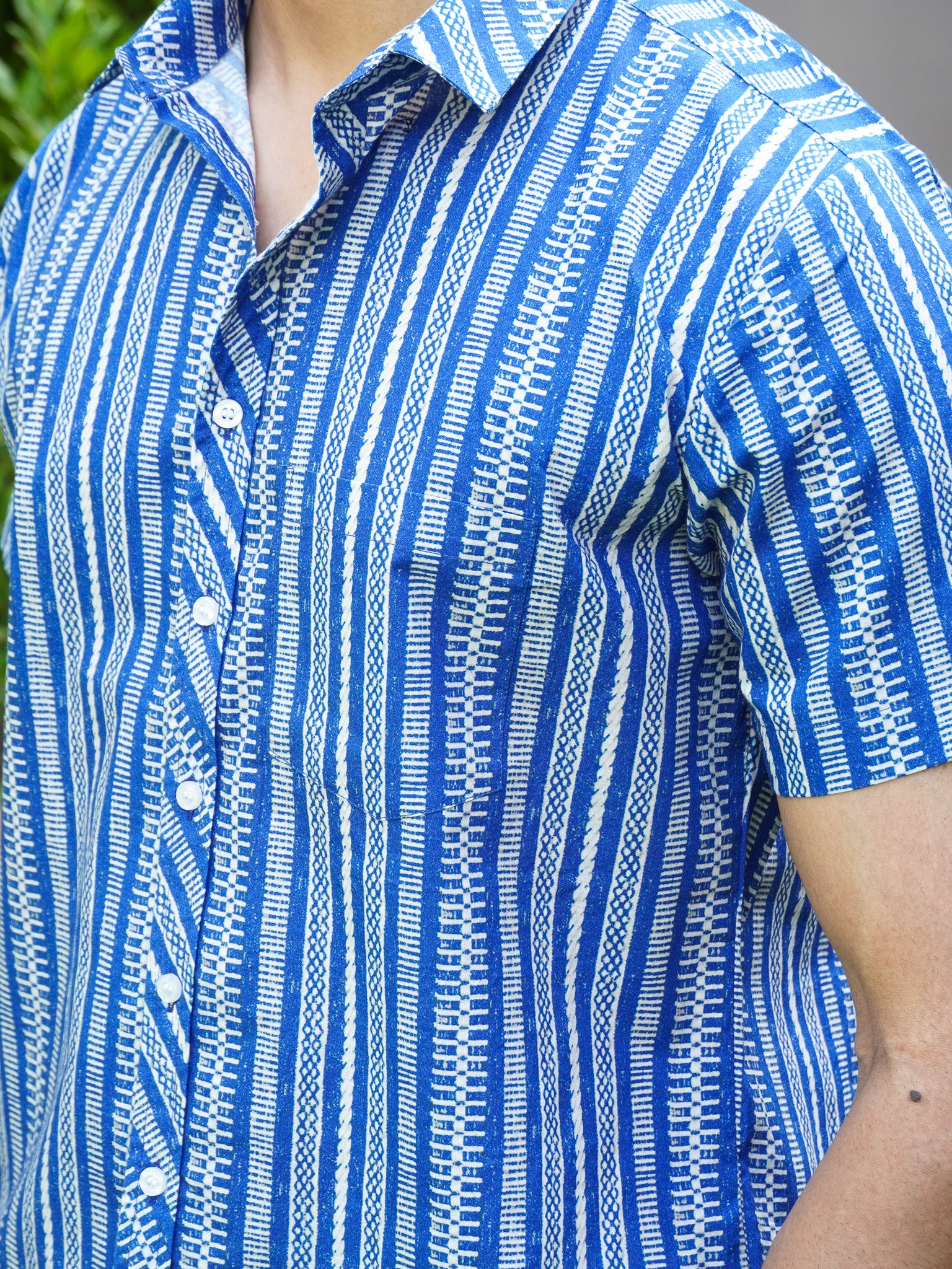 Close-up of white abstract striped print on blue cotton shirt