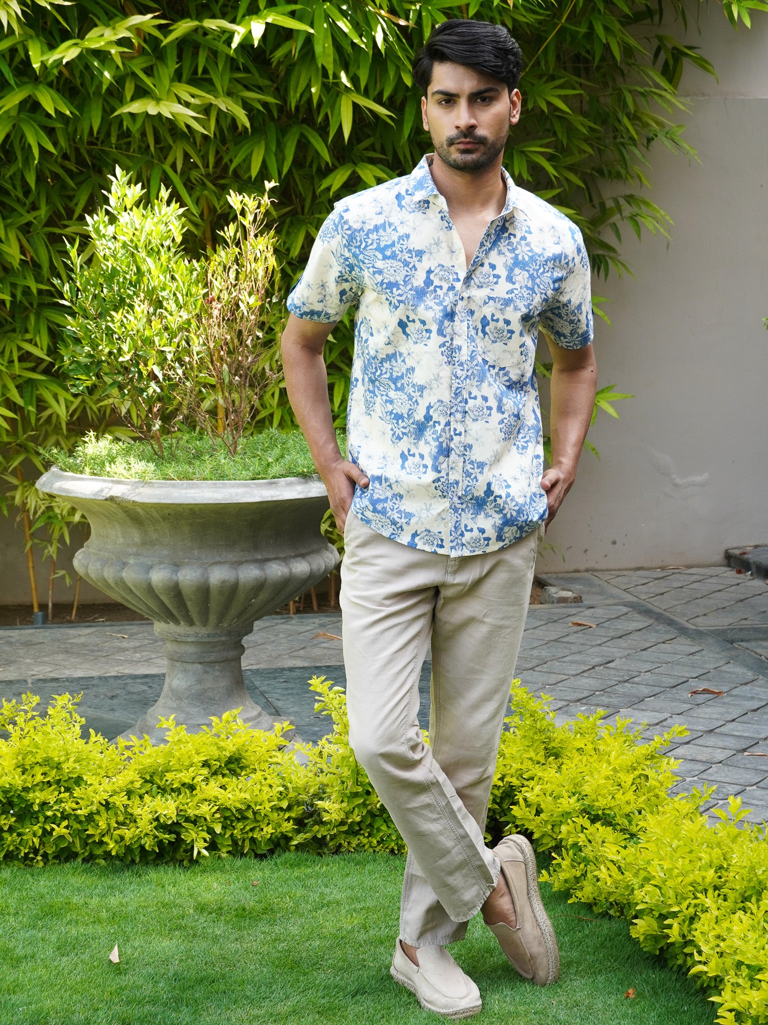 Model wearing men’s white and blue botanical print half sleeve shirt
