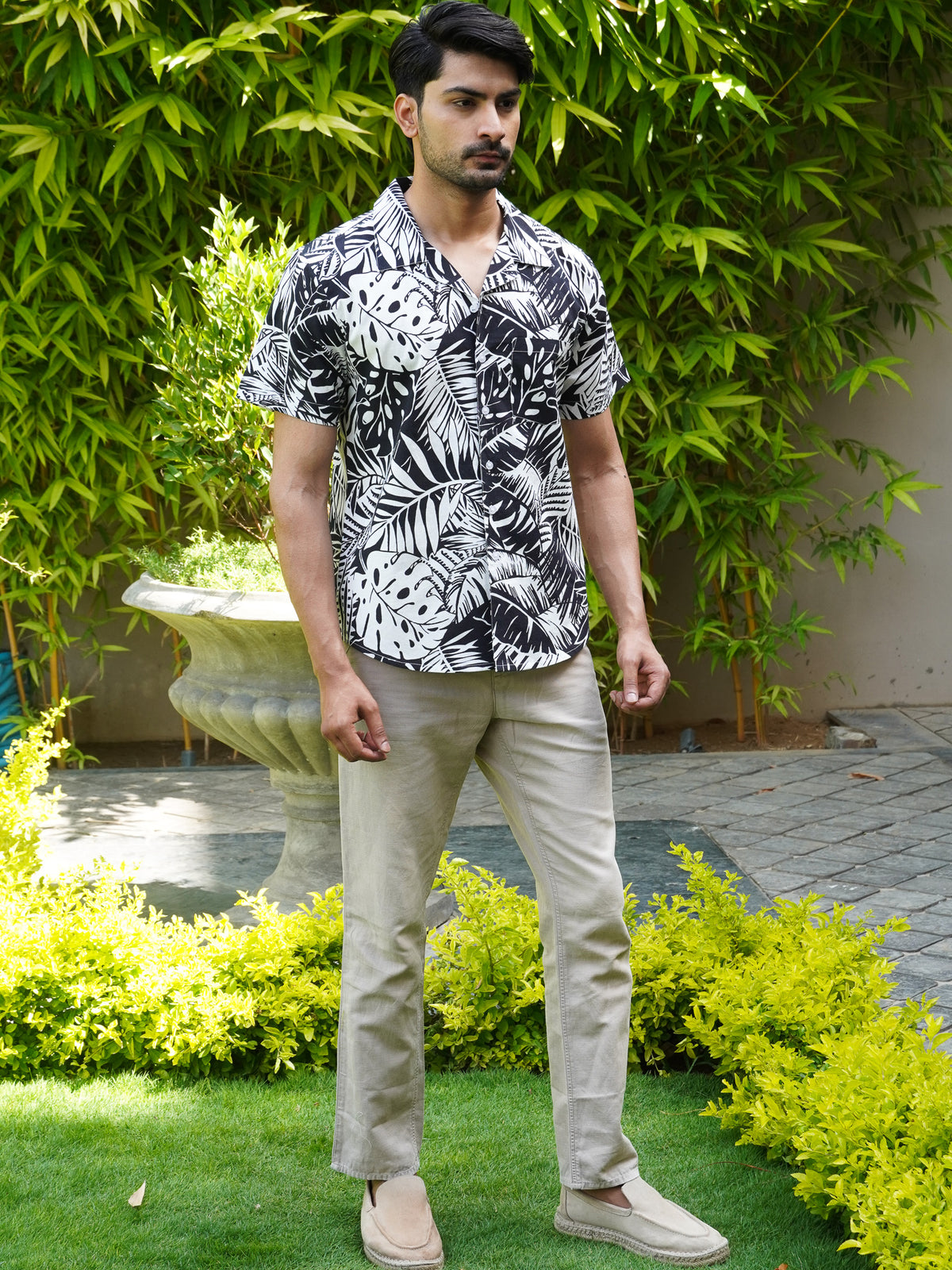 Model wearing men’s black and white tropical leaf print shirt