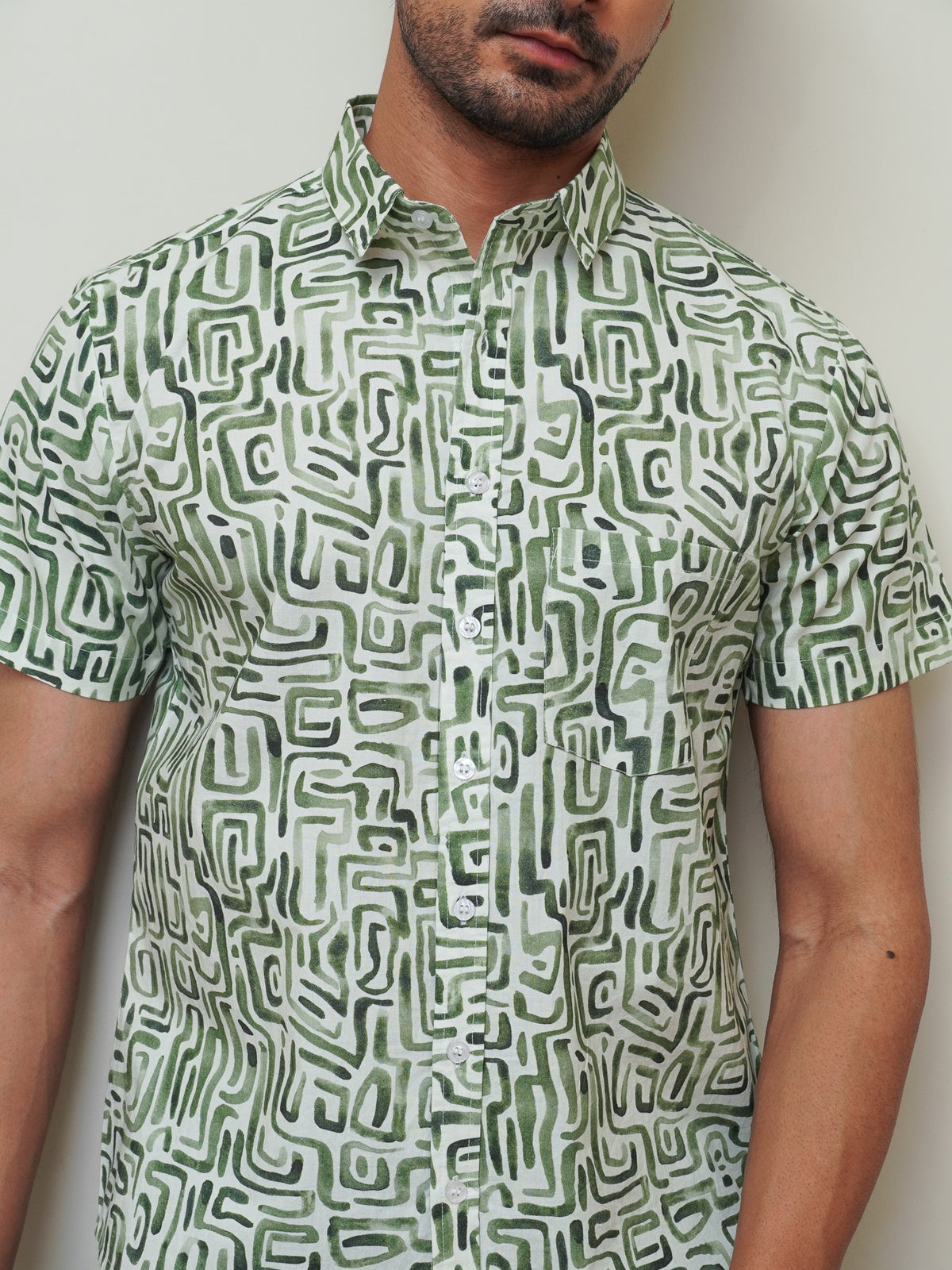 Close-up of green maze-inspired geometric motifs on light fabric