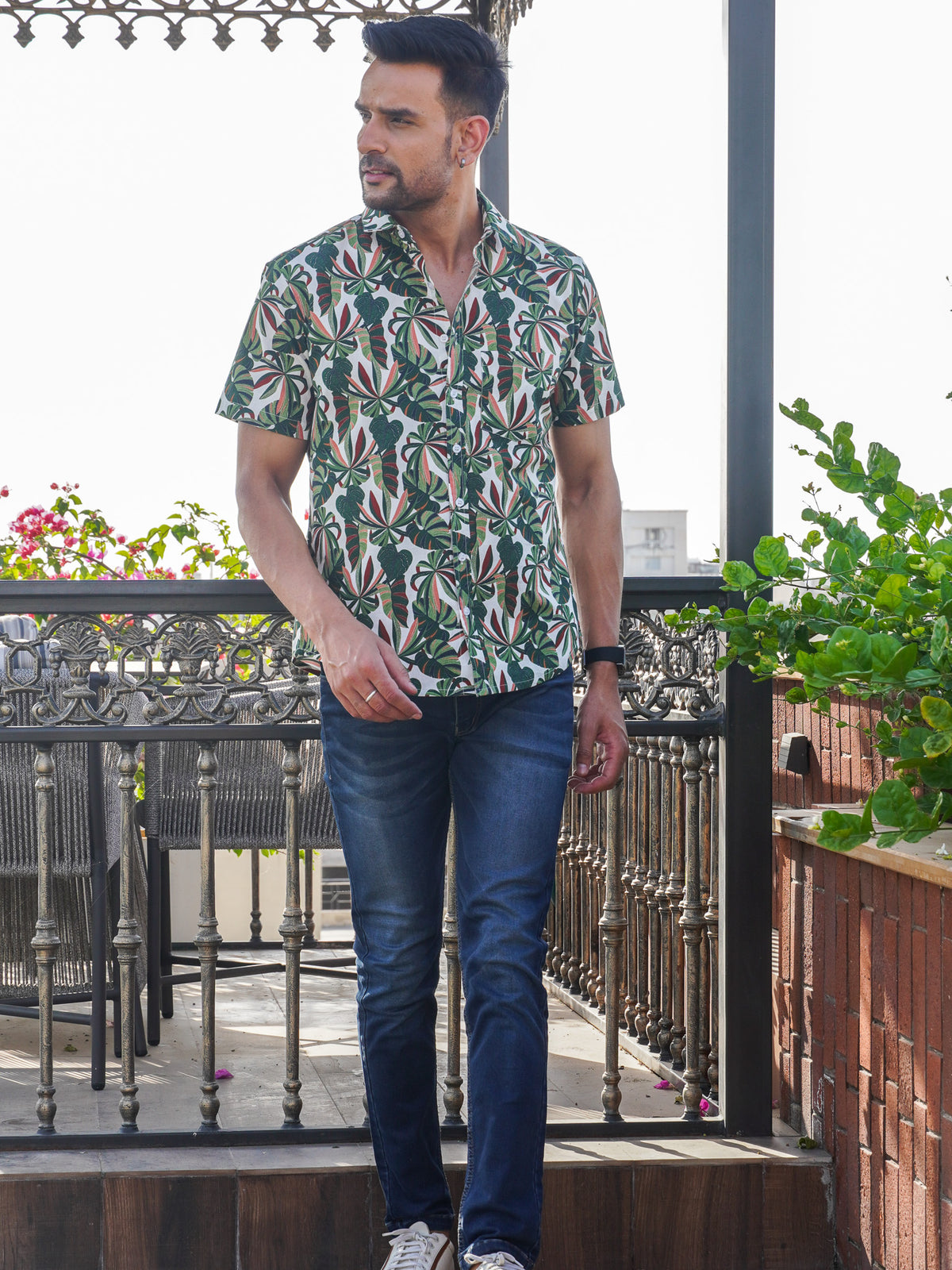Model wearing a green tropical leaf printed cotton shirt