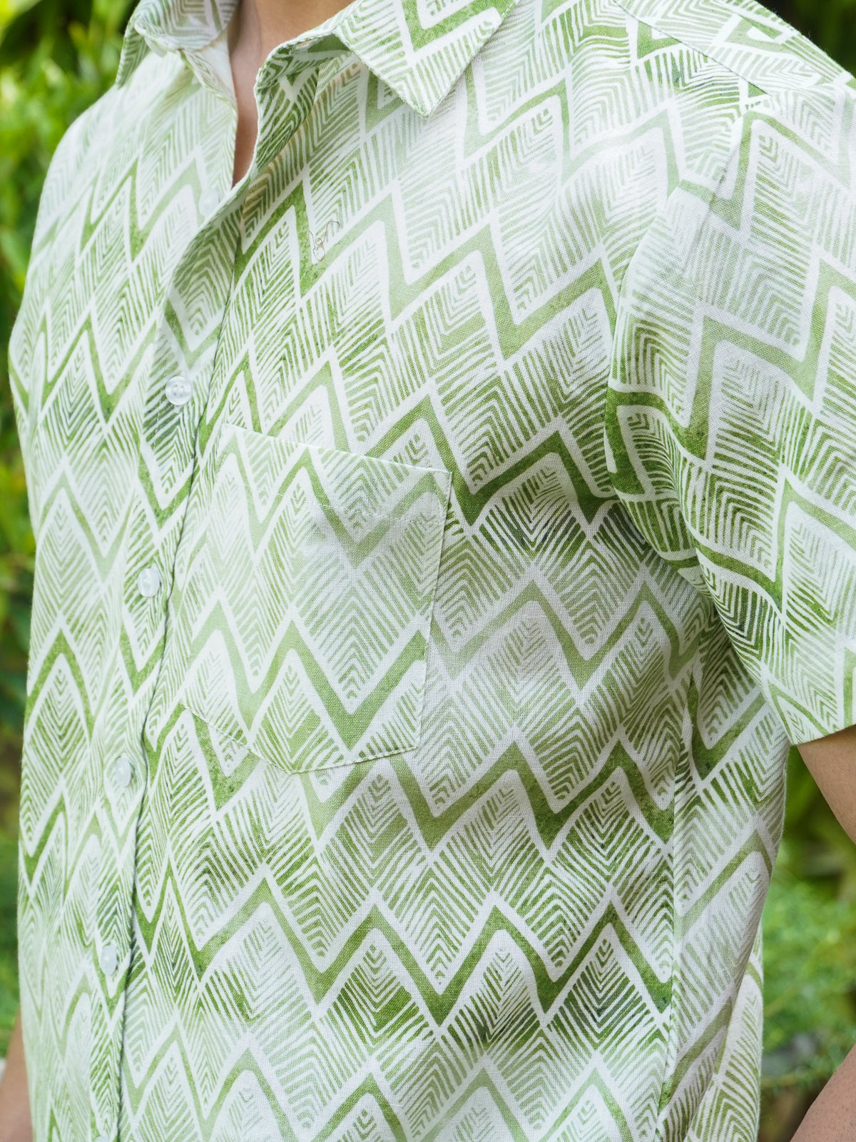 Close-up of green zigzag and geometric motifs on light cotton fabric