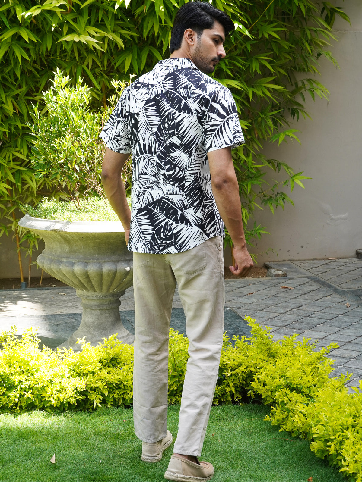 Back view of men’s black and white tropical leaf print shirt