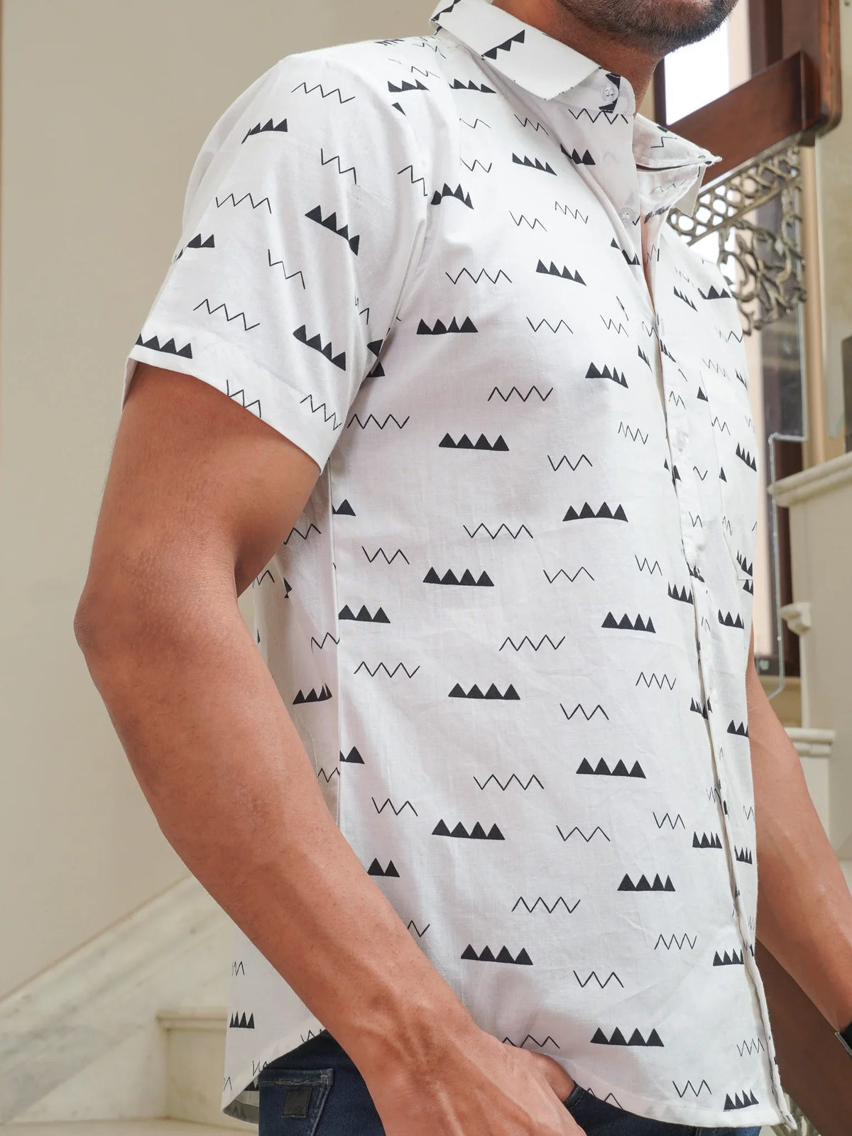 Close-up of black triangle and wave motifs on white cotton shirt