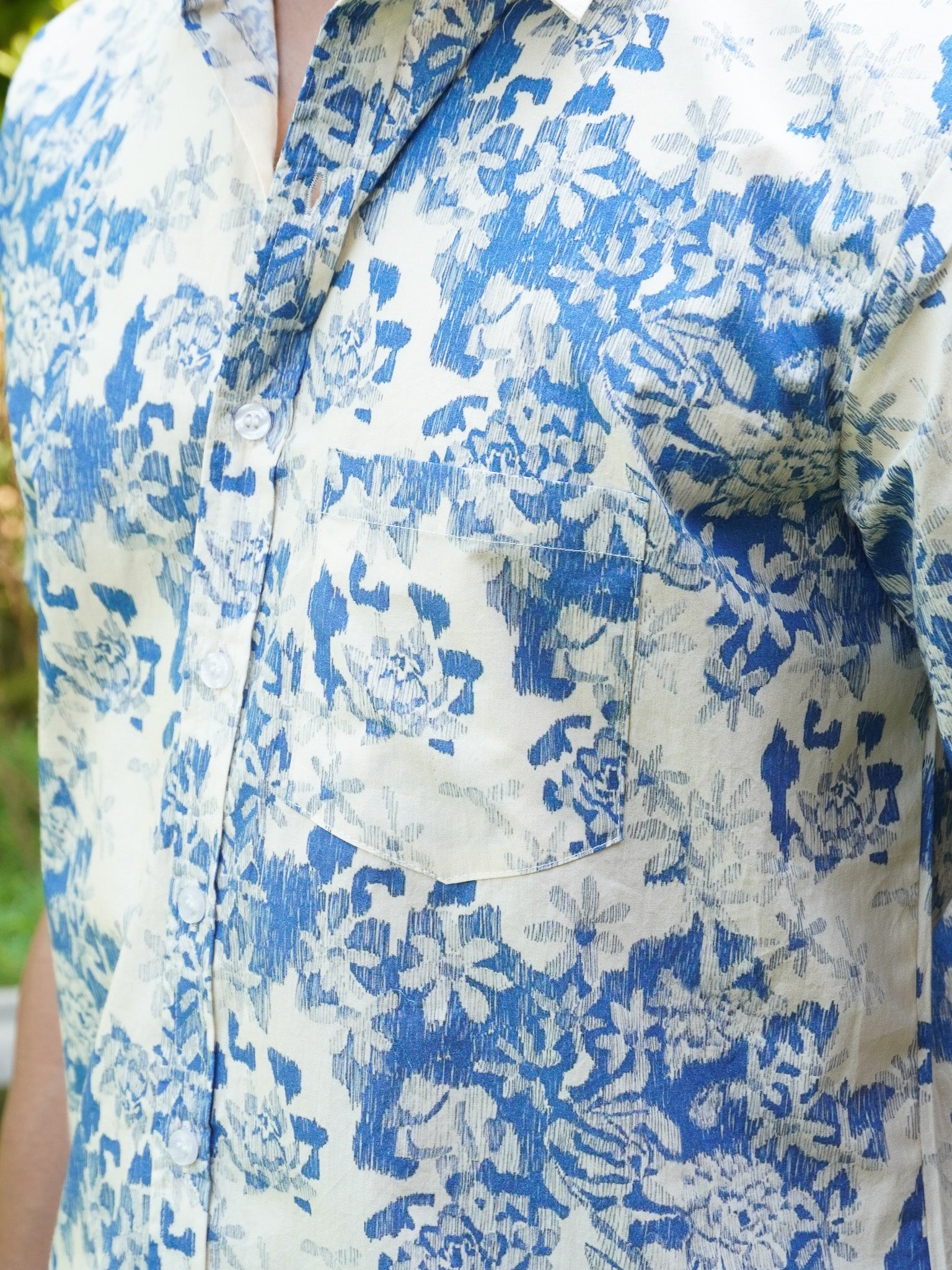 Close-up of blue floral and leaf print on white cotton shirt