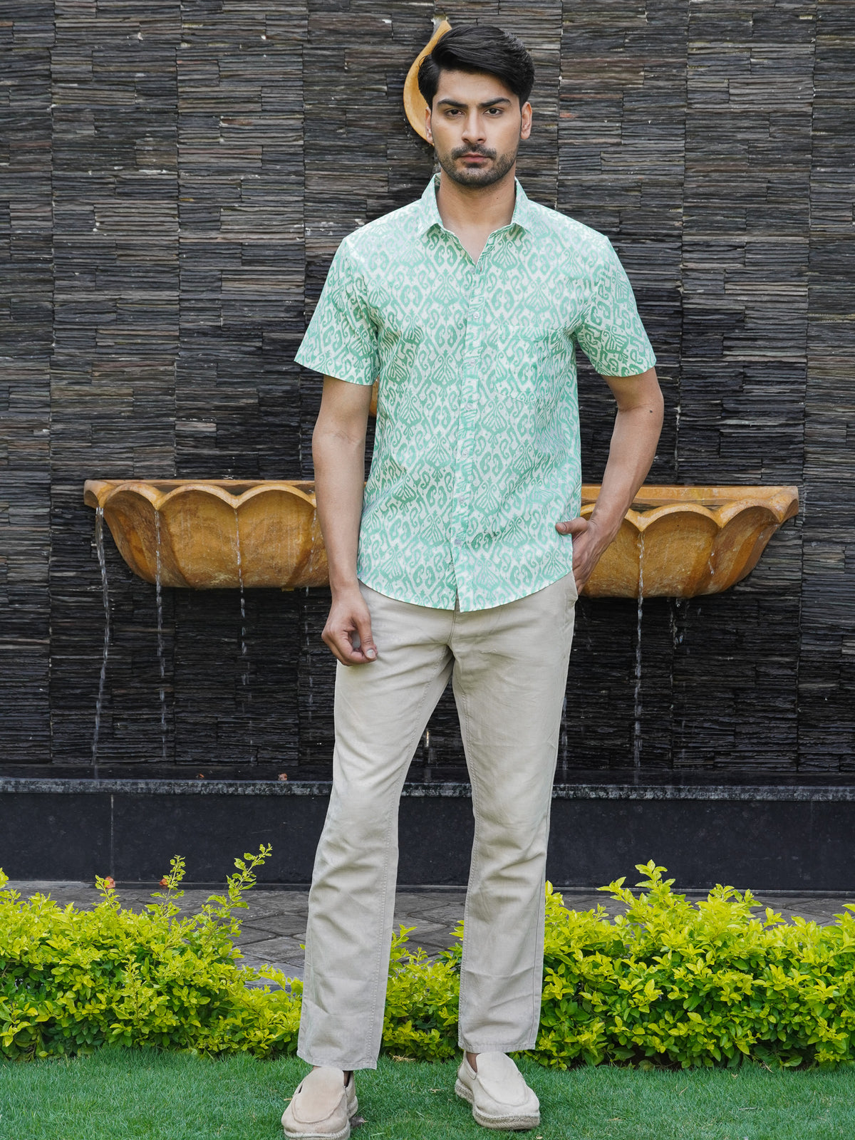 Model wearing a green geometric printed cotton half sleeve shirt
