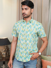 Model wearing a green leaf printed cotton half sleeve shirt