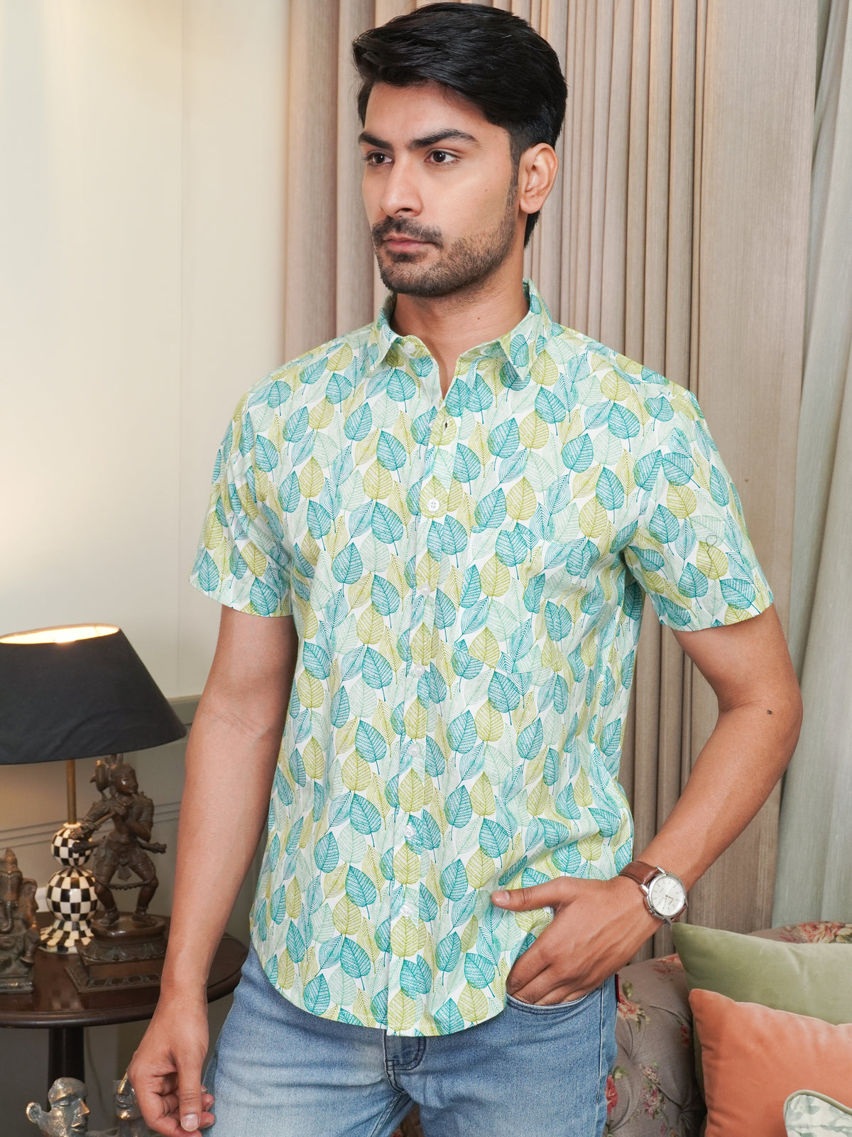 Model wearing a green leaf printed cotton half sleeve shirt