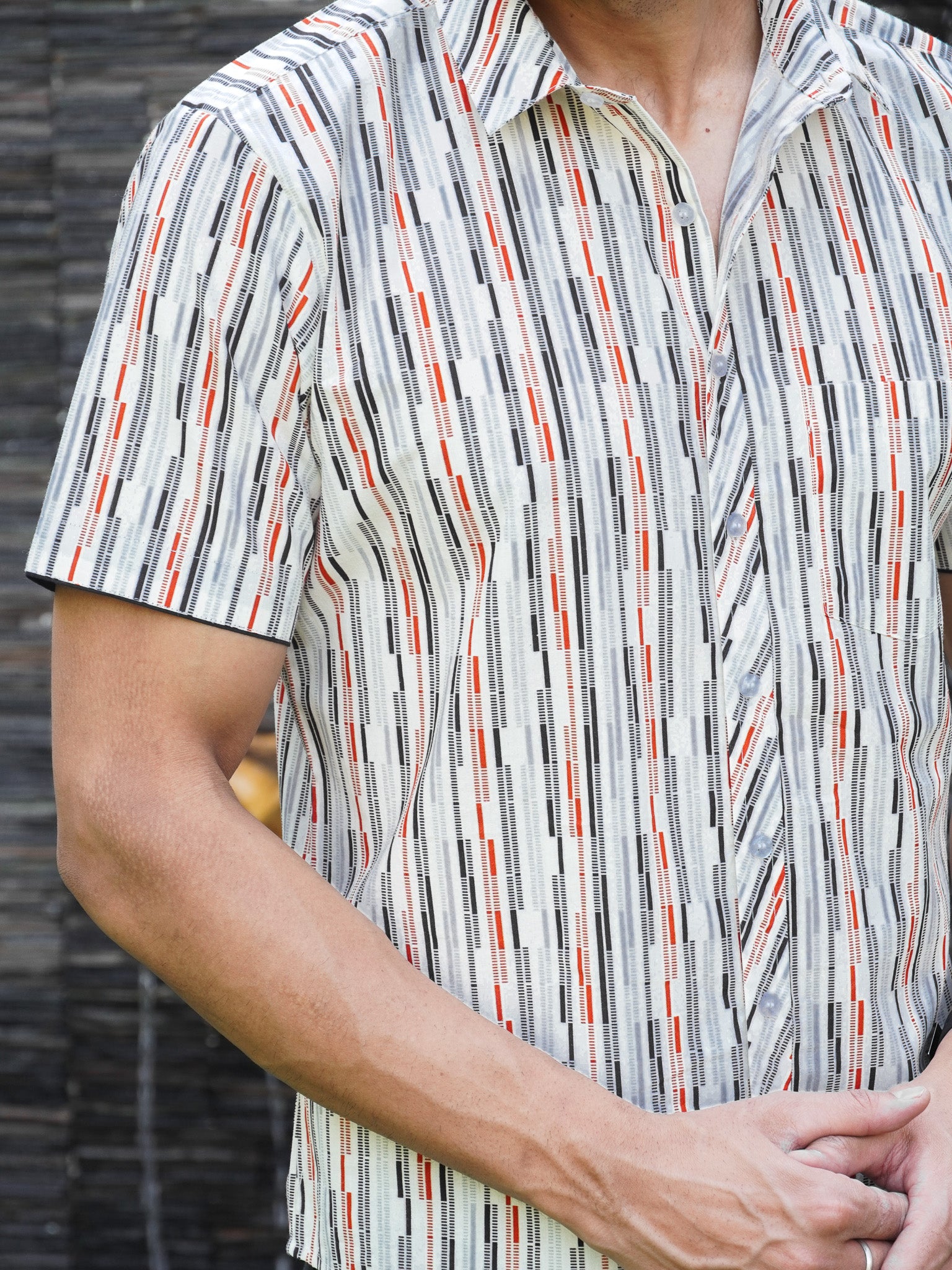 Close-up of black grey rust and green checked stripe print on cotton shirt