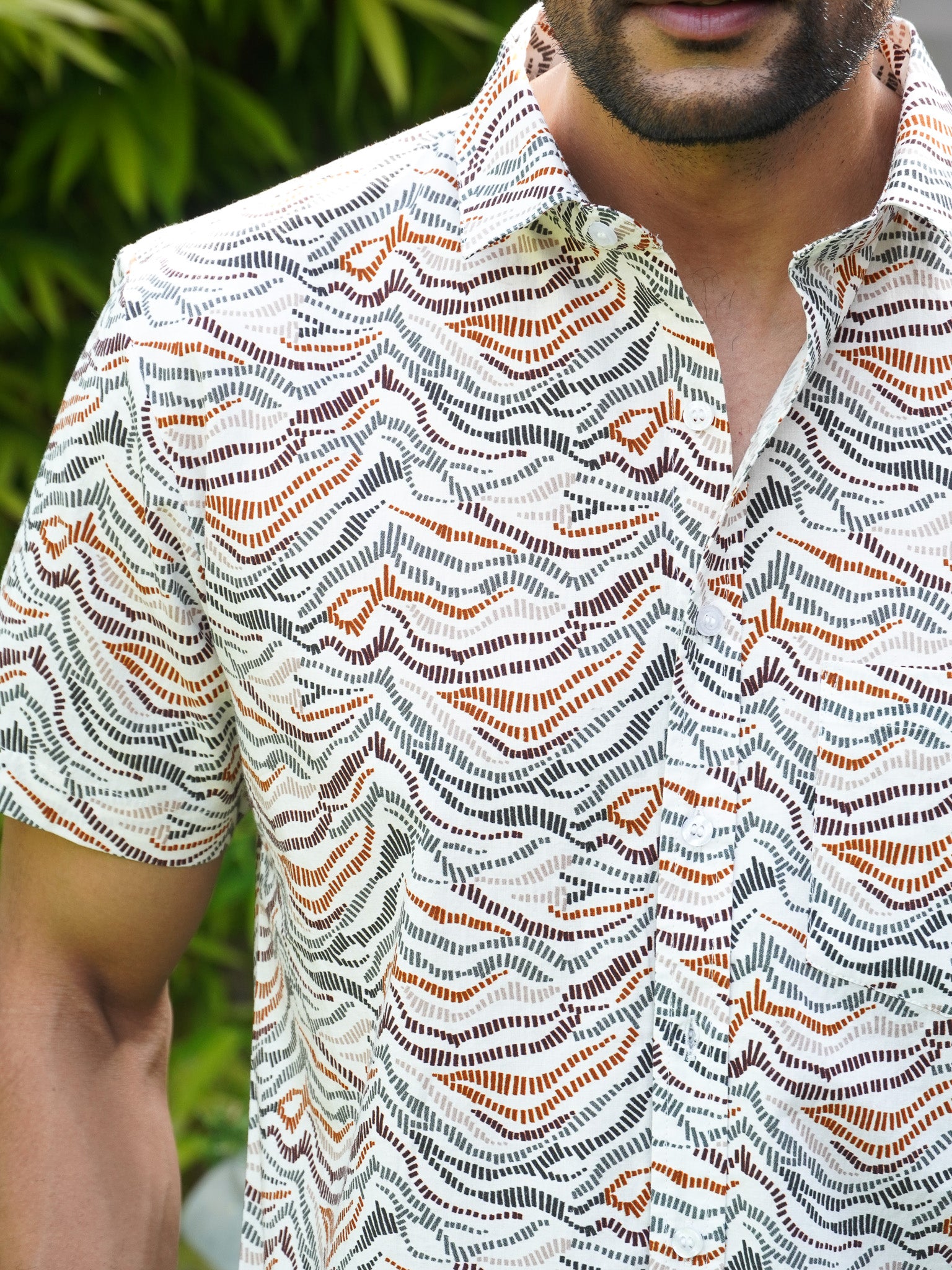 Close-up of black grey rust and green wave print on cotton shirt