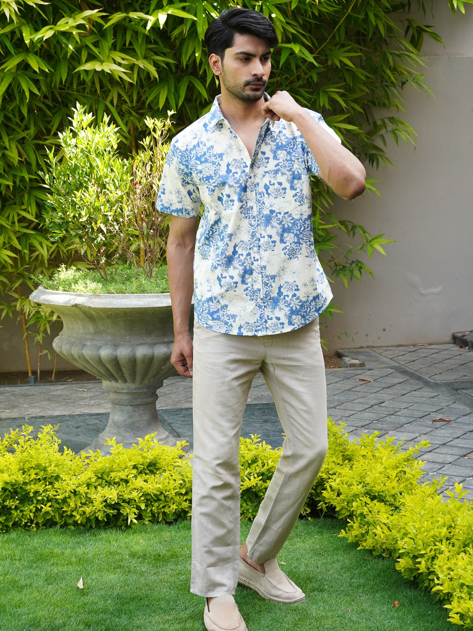 Model wearing men’s white and blue botanical print half sleeve shirt