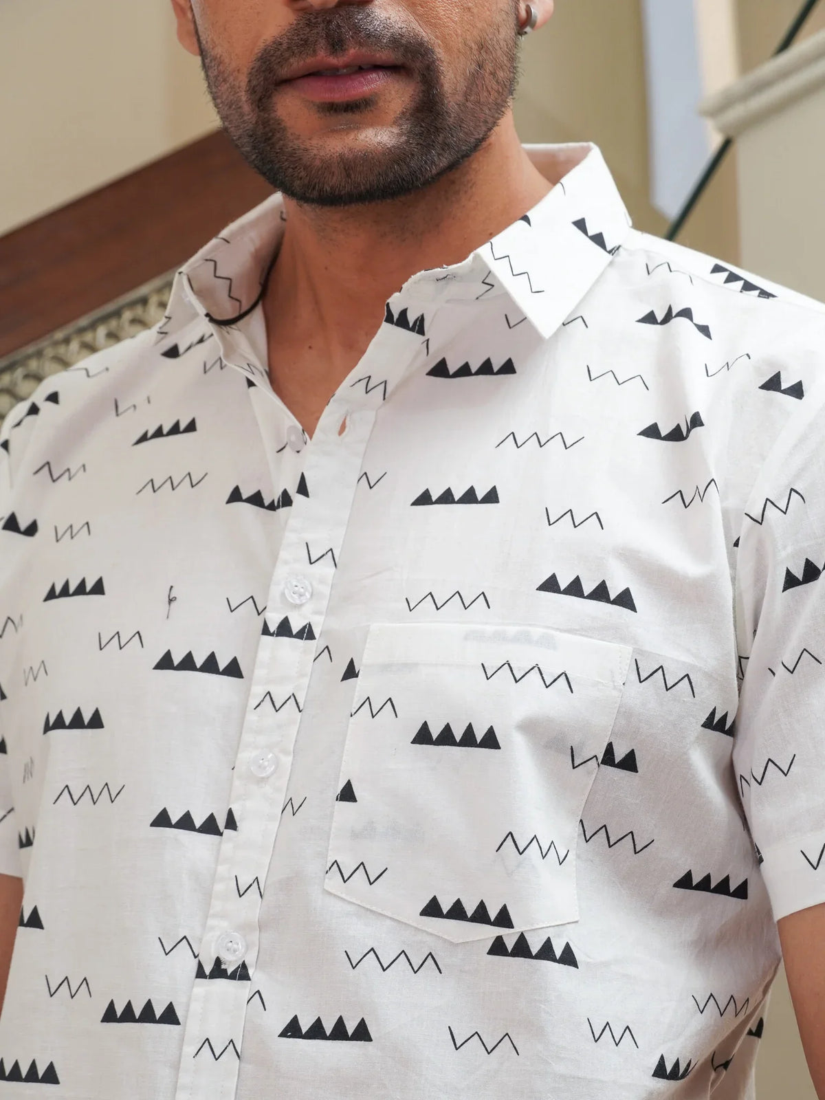 Model wearing men’s white black abstract print half sleeve shirt