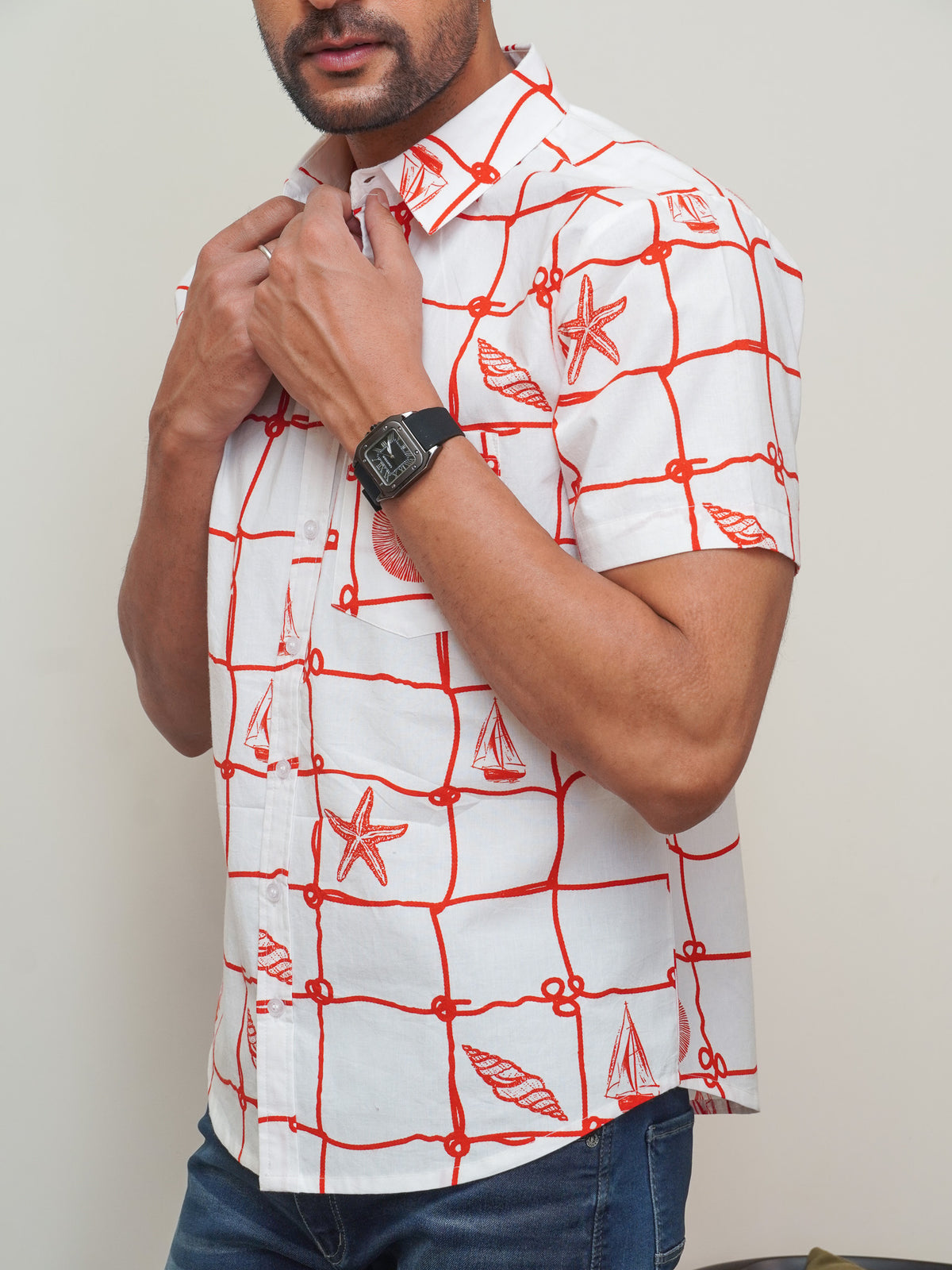Close-up of red sailboat rope shell and starfish print on white cotton shirt